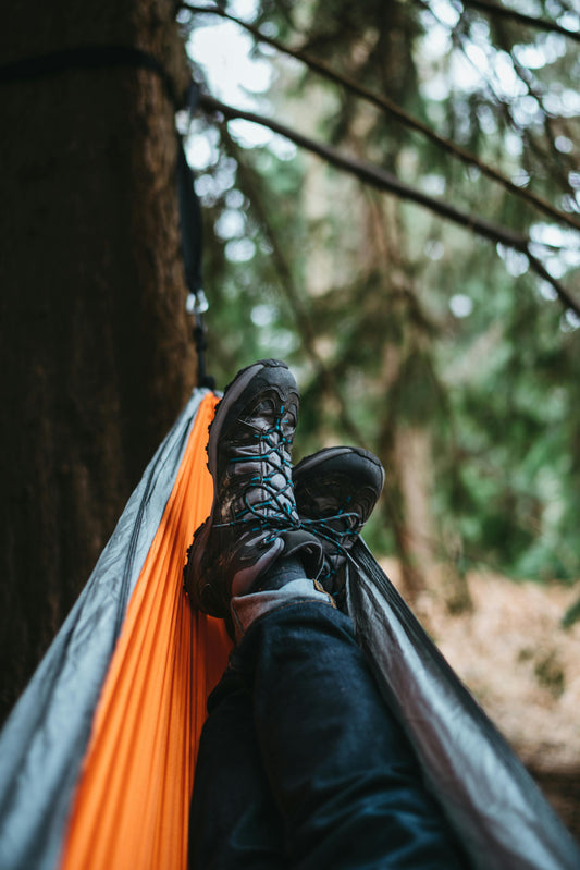 Person laying in a hammock, on a hiking trip